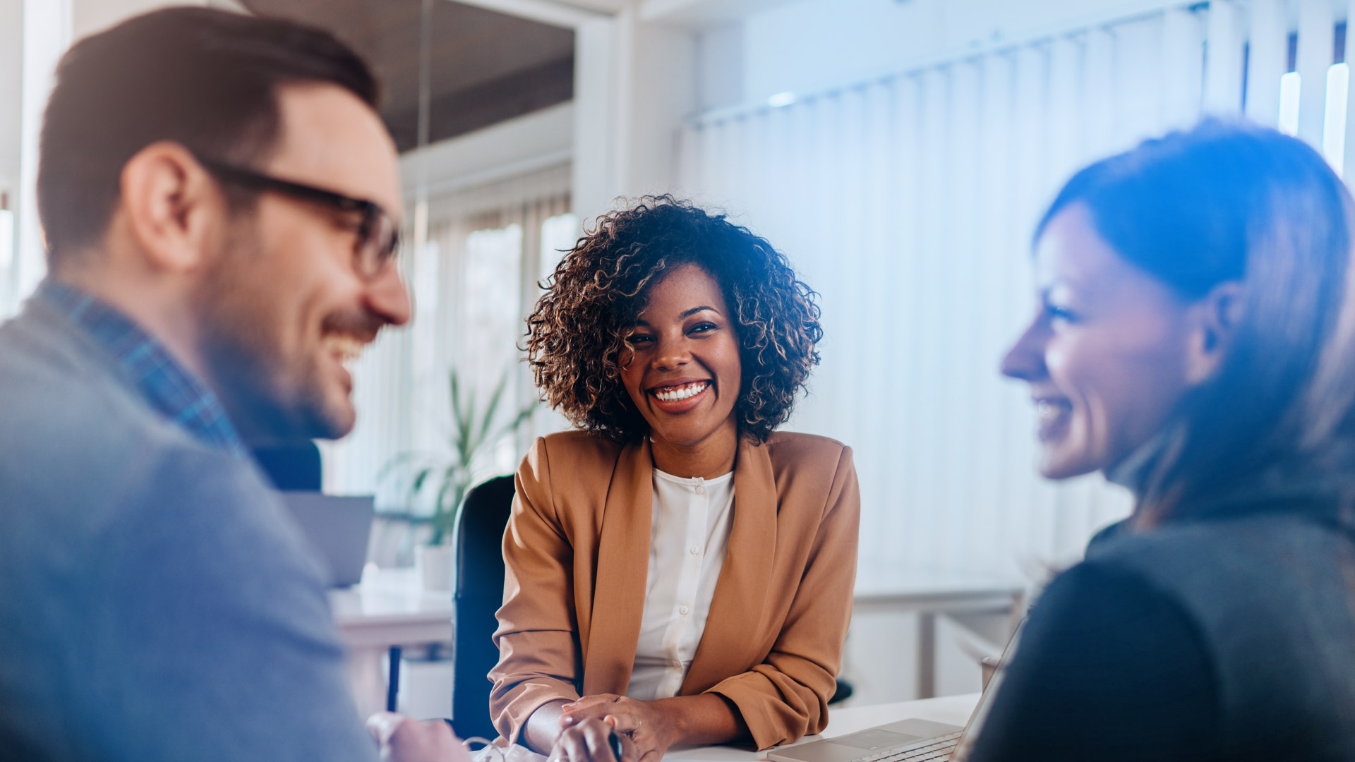 Woman with laptop smiles at man