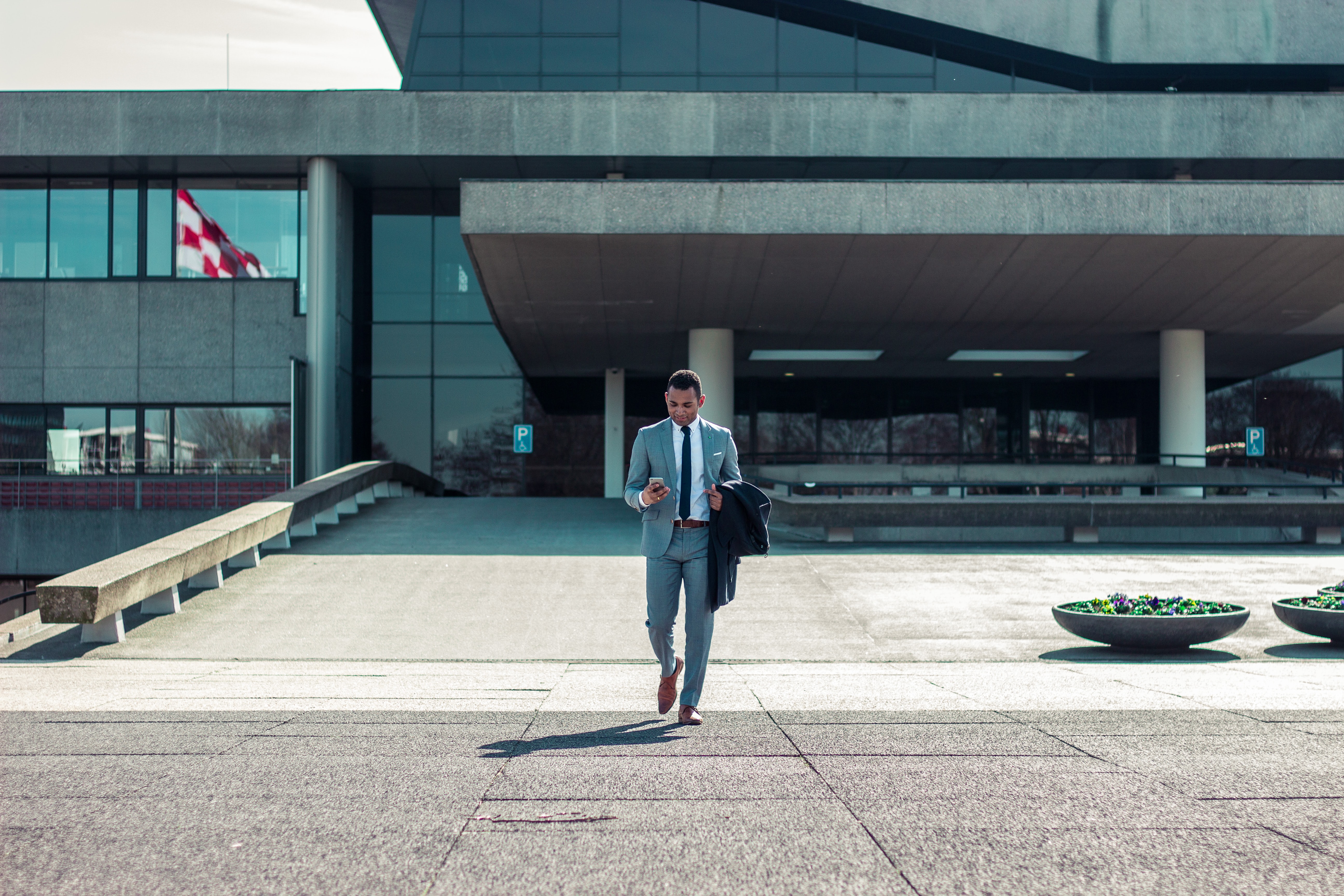 Businessman walks out of building.